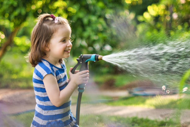 istock Playful girl holding a hose 1324898554