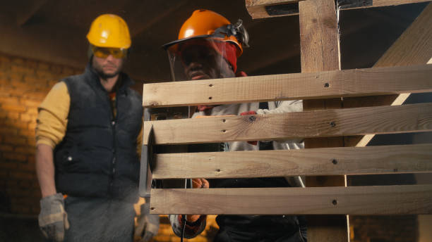 istock Diverse male carpenters cutting timber boards together 1324899707