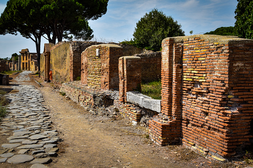 Ancient roman ruins, brick walls and roads with trees in Ostia Antica