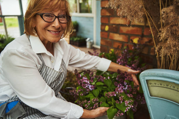 istock Happy elderly female with lilac bouquet on terrace 1324904395