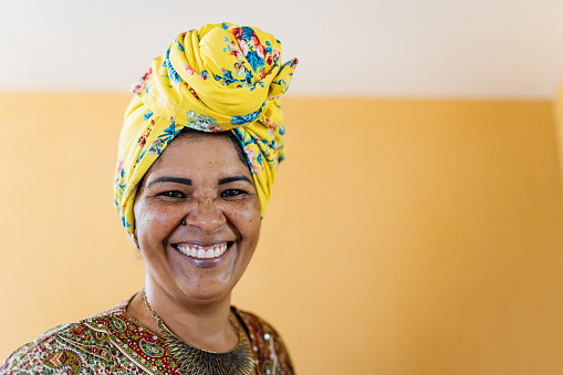 Women smiling wearing a fruit and flower headwrap
