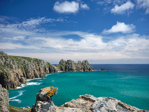 Scenic views across Pedn Vounder Beach, South Cornwall at high tide on a sunny June day.