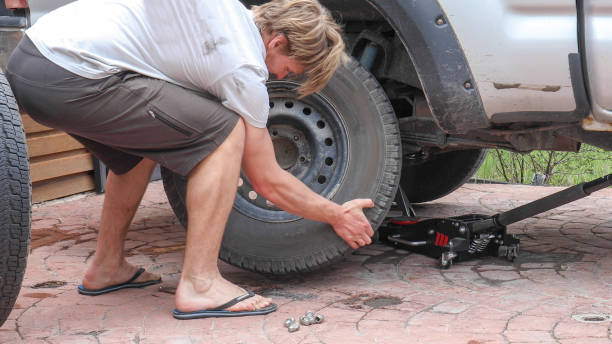 istock Young man changes tire on truck at home 1324910189