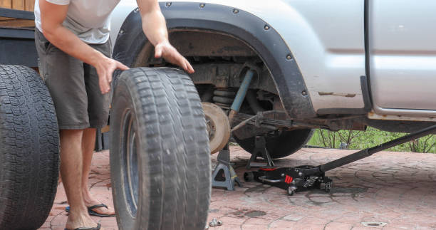 istock Young man changes tire on truck at home 1324910208