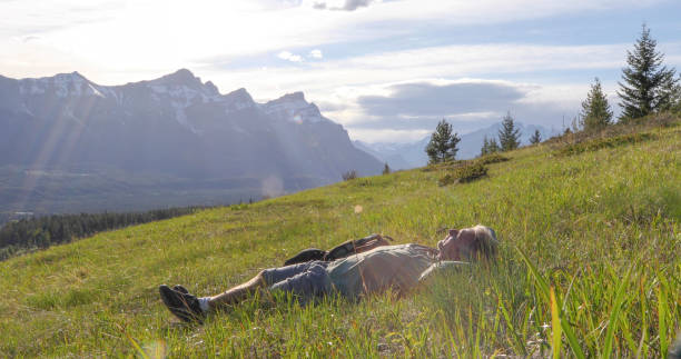 istock Hiker relaxes on grassy mountain ridge in the morning 1324910547