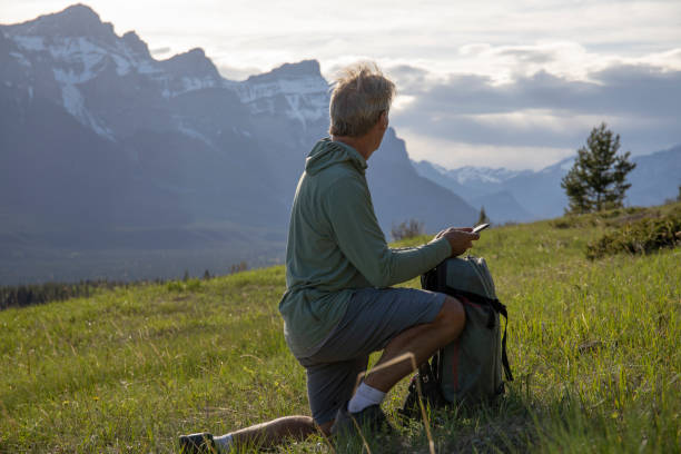 istock Hiker checks cellphone for directions on grassy mountain ridge 1324911431