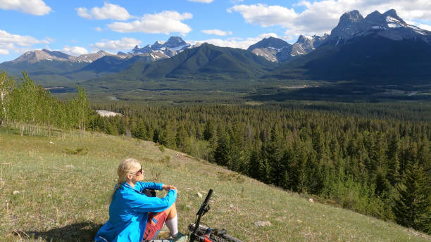 istock Female mountain biker relaxes on grassy mountain ridge 1324911550