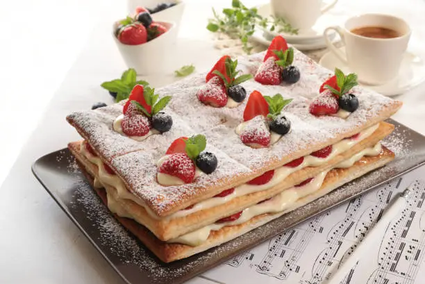 Strawberries, blueberries and Cream Mille Feuille dessert, mint leaves decoration. Directly above.