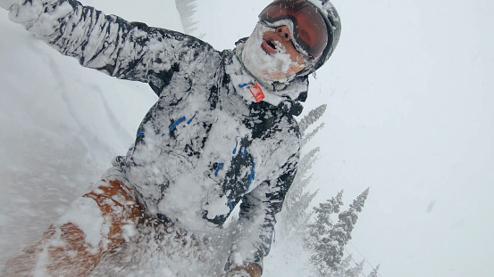POV looking backwards. Heavy snow sprays his face