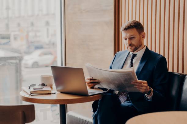 istock Male business company worker reading newspaper while working in cafe 1324918044