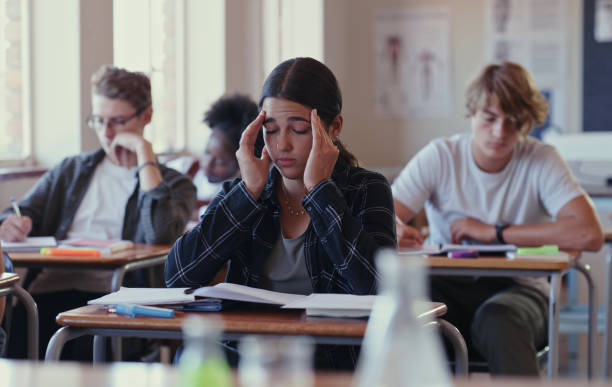 Shot of a student struggling with schoolwork in a classroom This is too much work to take in sad 15 years old girl stock pictures, royalty-free photos & images