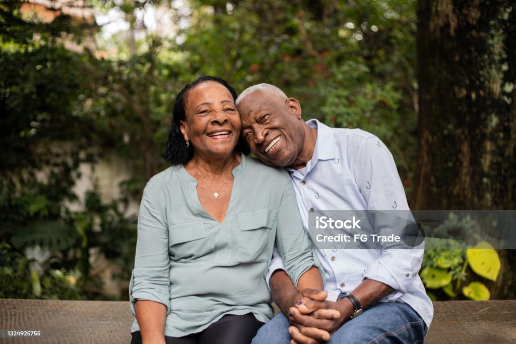 Portrait of a happy senior couple sitting together outdoors Senior Adult Stock Photo