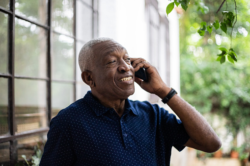 Senior man on a call using smartphone outdoors