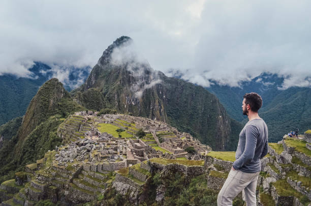 istock Young man standing contemplating Machu Picchu 1324928715