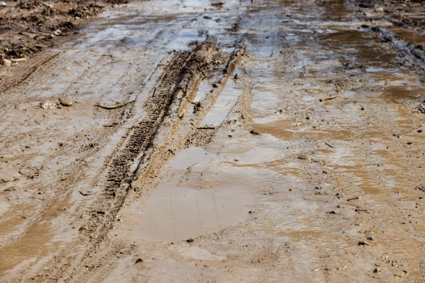 spring slush on a rural road. mud and puddles on the road - dirt road textured dirt mud imagens e fotografias de stock