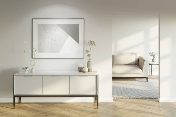 Modern white interior with an illuminated horizontal poster above a light-colored cabinet with decor, a doorway to a room with a sofa, and a coffee table with a parquet floor. Front view. 3d render dresser domestic room entrance hall home interior stock pictures, royalty-free photos & images
