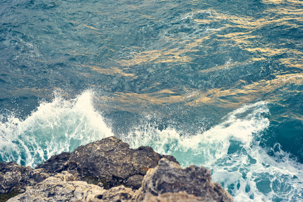 istock Splashes from the waves bumping against the rocky shore 1324932830