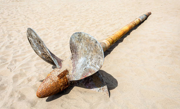 istock Old rusty ship propeller of a marine ship on the sand 1324936635