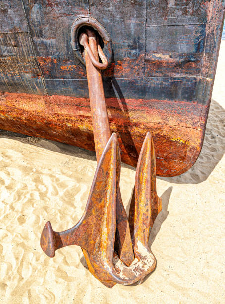 istock Old rusty anchor of an abandoned ship on the sand beach 1324936675