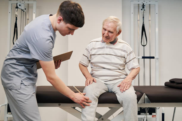 istock Manual therapist touching aching knee of elderly person 1324940503