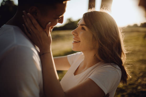 istock Lovely couple in meadow enjoy the sunset 1324943320