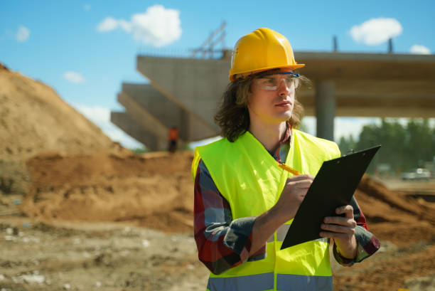 istock Builder with documents on the background of a road junction construction site. 1324944050
