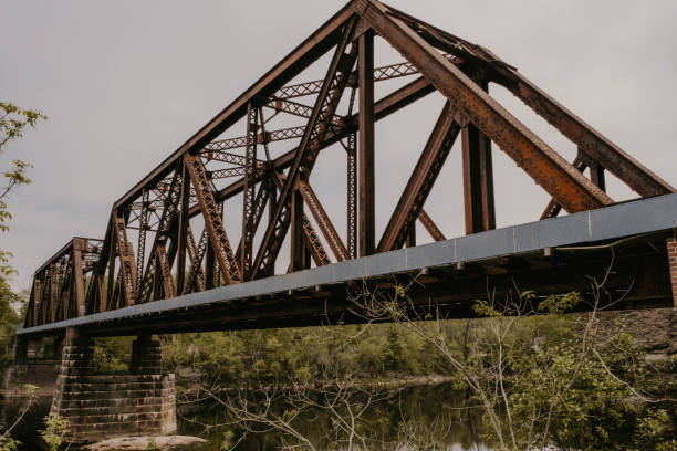 istock Iron rung bridge crossing a river on a cloudy afternoon. 1324950500