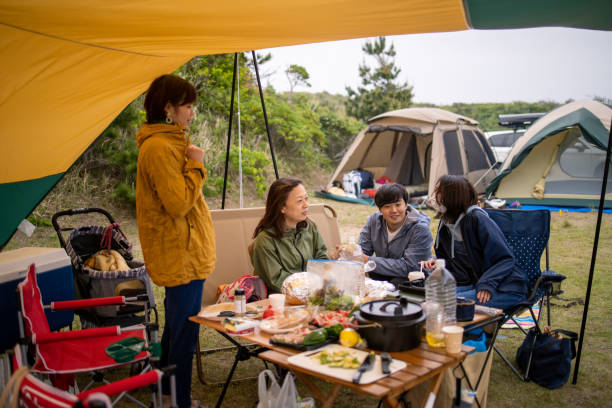 Families eating foods and talking at camp stock photo