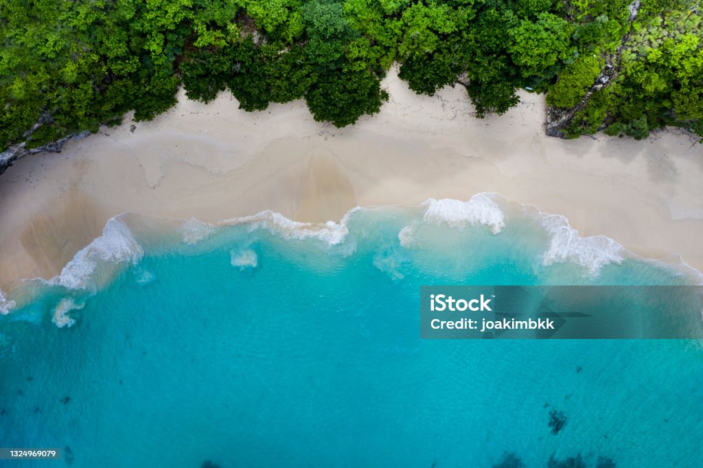 Idyllic white sand beach in Bali Indonesia Aerial drone abstract landscape of a magnificent turquoise water white sand beach located in Nusa Penida in Bali Indonesia. Nusa Penida Stock Photo