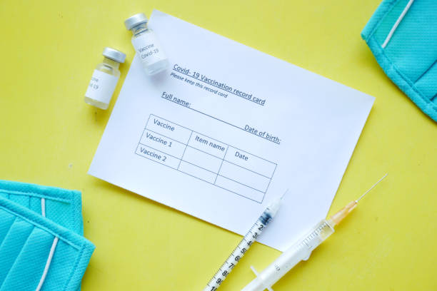 istock vaccination record card , vaccine , syringe and mask on yellow 1324974751
