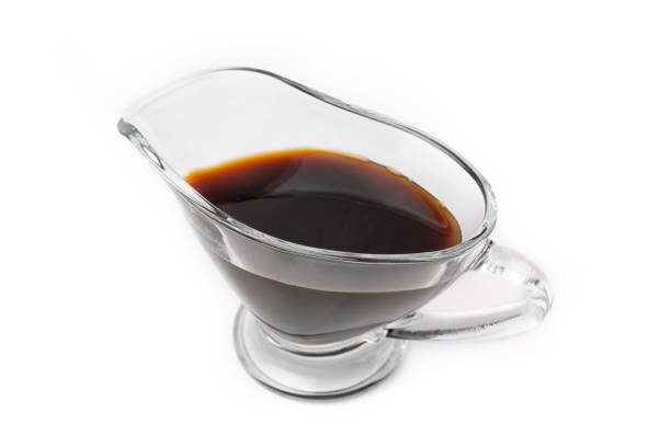 istock Soy sauce in a glass saucepan, isolated on a white background. 1324977279