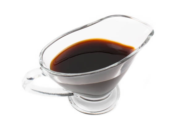 istock Soy sauce in a glass saucepan, isolated on a white background. 1324977282