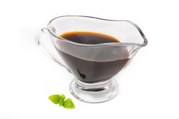 istock Soy sauce in a glass saucepan, isolated on a white background. 1324977295