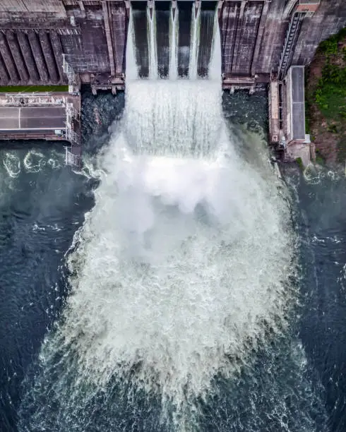 Photo of water discharge stream waterfall at the hydroelectric dam. an overflowing reservoir, a huge jet of water, aerial , a drone, the Yenisei river siberia Krasnoyarsk