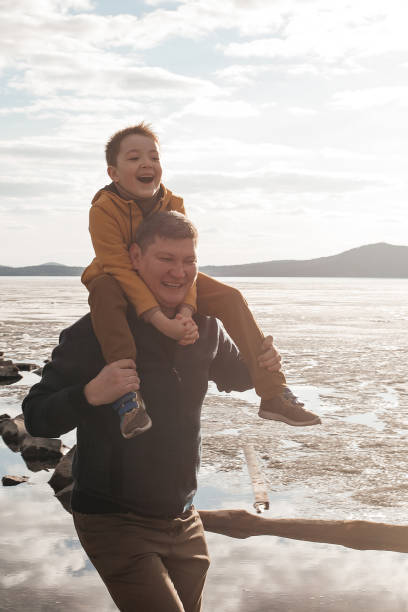 istock Dad plays with his son on the riverbank. 1324983436