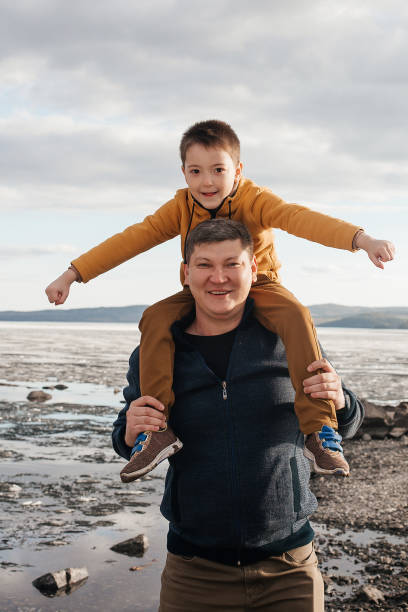 istock Dad plays with his son on the riverbank. 1324983457