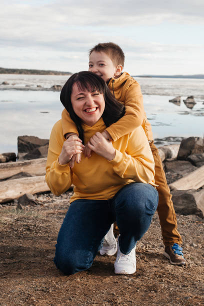 Mom plays with her son on the riverbank