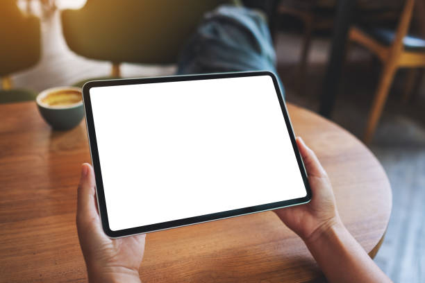 istock a woman holding digital tablet with blank white desktop screen 1324985181