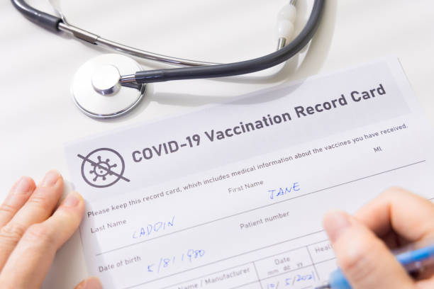 istock woman write vaccination record card 1324986730