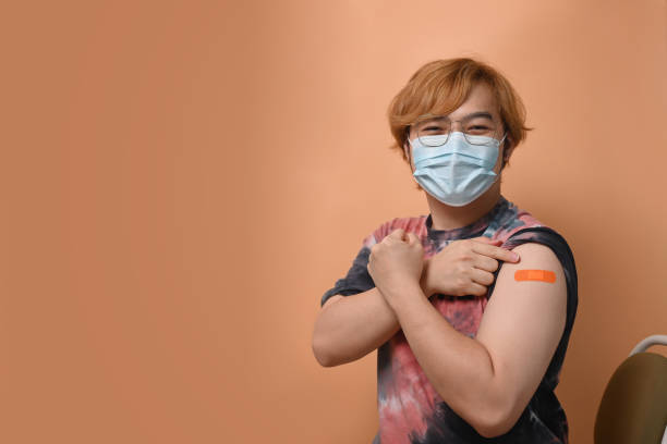 istock Happy young man showing arm after vaccine injection. Vaccination and immunization. 1324991435
