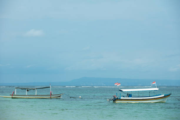Azure sea with rolling waves and boats and blue sky, summer background