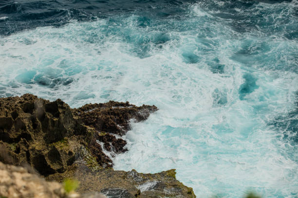 istock Sea foam wave running on a rocky shore top view, summer background 1324992458