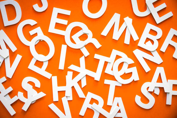 istock Mixed letters pile top view photo. Orange background 1324994727