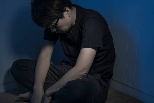 istock A man sitting at a loss in a dark room 1324995556