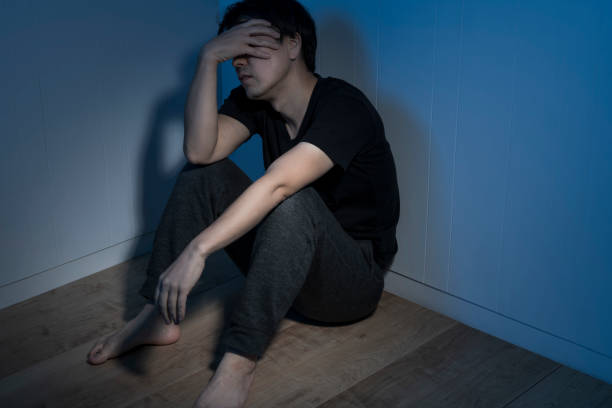 istock A man sitting at a loss in a dark room 1324995586