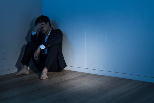 暗い部屋で途方に暮れた男 - 夜怖い 日本人 ストックフォトと画像