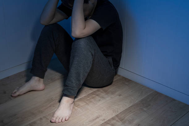 A man sitting at a loss in a dark room