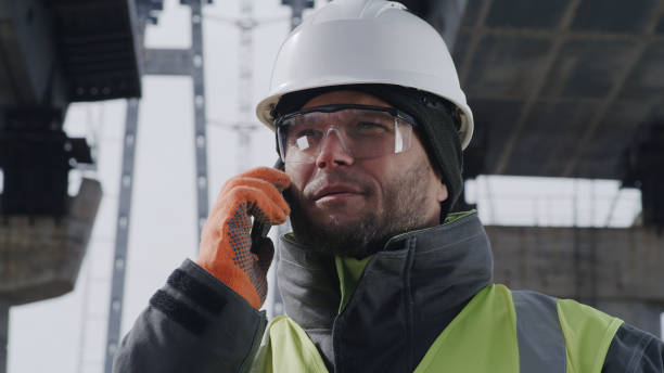 istock Male worker answering phone call under unfinished bridge 1324996624