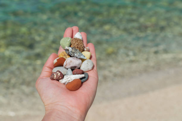 istock woman sitting at sea beach playing with rocks 1324996856