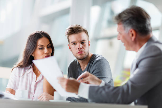 istock Young couple going through plans with their insurance agent in the office. 1325001843